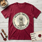 I Stand Amazed in the Presence Goldendoodle T-Shirt flat lay in Antique Cherry Red, featuring a vintage engraving medallion of a haloed Goldendoodle with a small devoted human gazing up from below.