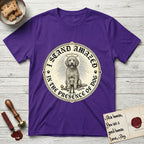 I Stand Amazed in the Presence Goldendoodle T-Shirt flat lay in Purple, featuring a vintage engraving medallion of a haloed Goldendoodle with a small devoted human gazing up from below.