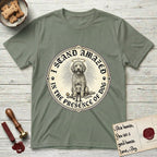 I Stand Amazed in the Presence Goldendoodle T-Shirt flat lay in Sage, featuring a vintage engraving medallion of a haloed Goldendoodle with a small devoted human gazing up from below.
