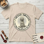 I Stand Amazed in the Presence Goldendoodle T-Shirt flat lay in Sand, featuring a vintage engraving medallion of a haloed Goldendoodle with a small devoted human gazing up from below.