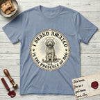 I Stand Amazed in the Presence Goldendoodle T-Shirt flat lay in Stone Blue, featuring a vintage engraving medallion of a haloed Goldendoodle with a small devoted human gazing up from below.