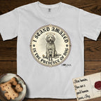 I Stand Amazed in the Presence Goldendoodle T-Shirt flat lay in White, featuring a vintage engraving medallion of a haloed Goldendoodle with a small devoted human gazing up from below.