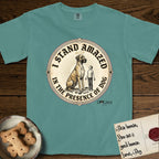 I Stand Amazed in the Presence Great Dane T-Shirt flat lay in Blue Spruce, featuring a vintage engraving medallion of a haloed Great Dane with a small devoted human gazing up from below.