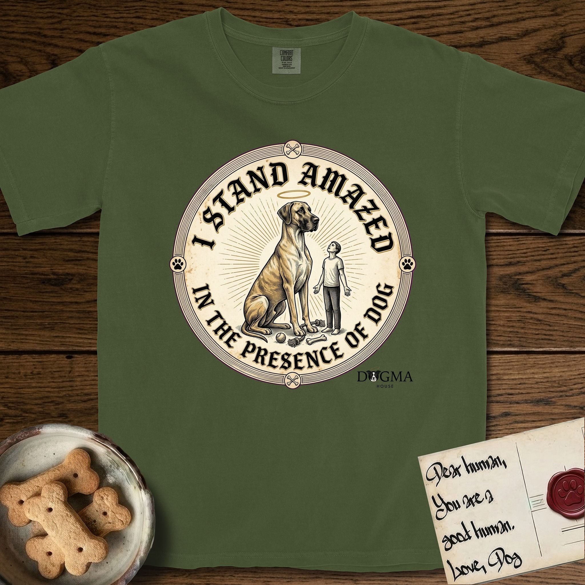 I Stand Amazed in the Presence Great Dane T-Shirt flat lay in Hemp, featuring a vintage engraving medallion of a haloed Great Dane with a small devoted human gazing up from below.