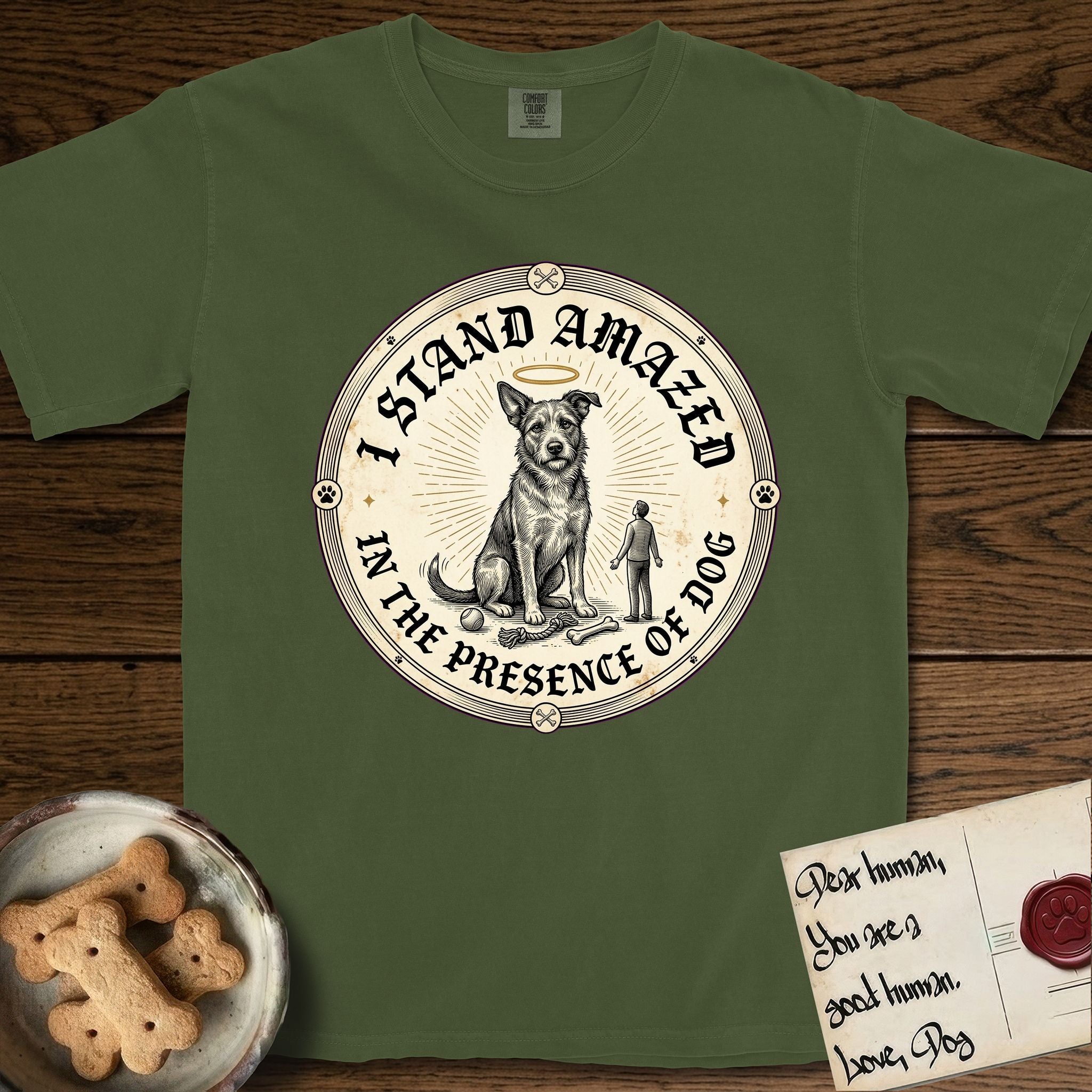 I Stand Amazed in the Presence Rescue Mutt T-Shirt flat lay in Hemp, featuring a vintage engraving medallion of a haloed rescue mutt with a small devoted human gazing up from below.