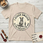I Stand Amazed in the Presence Rescue Mutt T-Shirt flat lay in Sand, featuring a vintage engraving medallion of a haloed rescue mutt with a small devoted human gazing up from below.