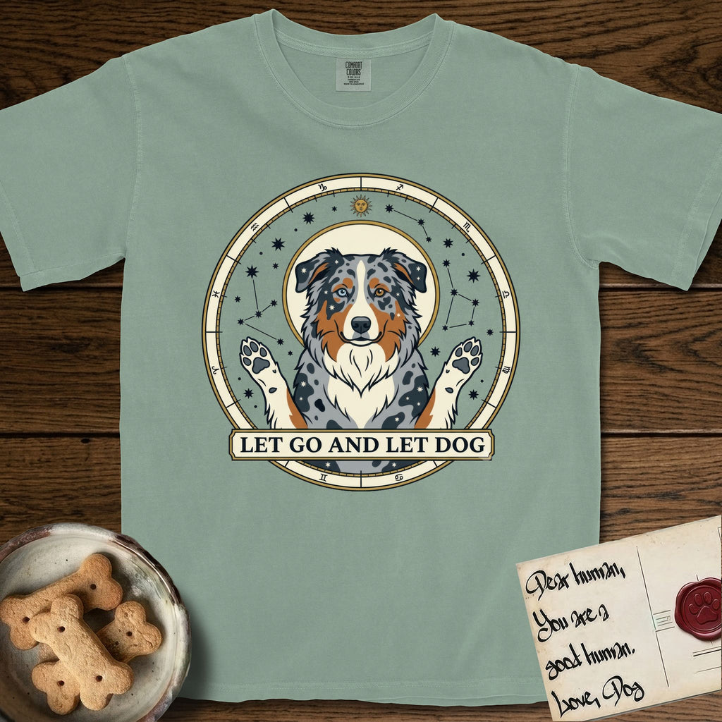 Let Go and Let Dog Australian Shepherd T-Shirt flat lay in Bay, featuring an antique celestial star chart with a haloed blue merle Australian Shepherd at the center, paws raised, stars scattered through her coat.