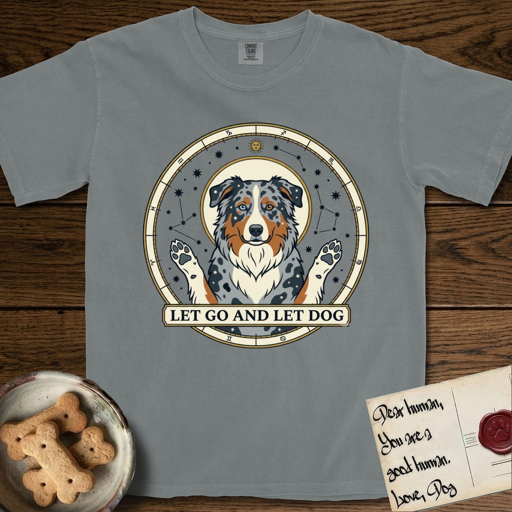Let Go and Let Dog Australian Shepherd T-Shirt flat lay in Granite, featuring an antique celestial star chart with a haloed blue merle Australian Shepherd at the center, paws raised, stars scattered through her coat.