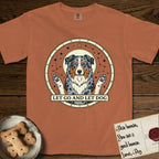 Let Go and Let Dog Australian Shepherd T-Shirt flat lay in Yam, featuring an antique celestial star chart with a haloed blue merle Australian Shepherd at the center, paws raised, stars scattered through her coat.