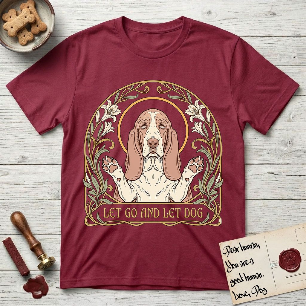 Let Go and Let Dog Basset Hound T-Shirt flat lay in Cardinal Red, featuring an Art Nouveau botanical illustration of a haloed Basset Hound with paws raised in blessing.