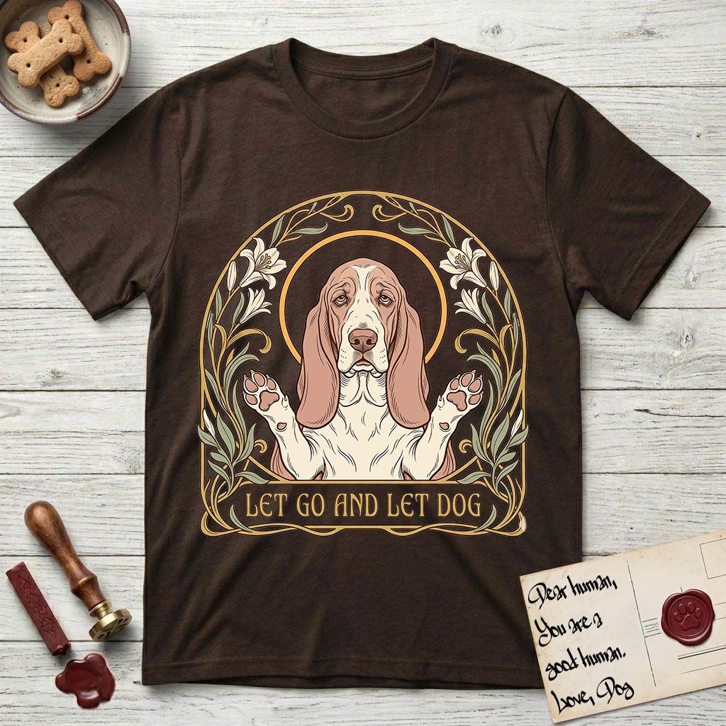 Let Go and Let Dog Basset Hound T-Shirt flat lay in Dark Chocolate, featuring an Art Nouveau botanical illustration of a haloed Basset Hound with paws raised in blessing.