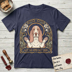 Let Go and Let Dog Basset Hound T-Shirt flat lay in Navy, featuring an Art Nouveau botanical illustration of a haloed Basset Hound with paws raised in blessing.