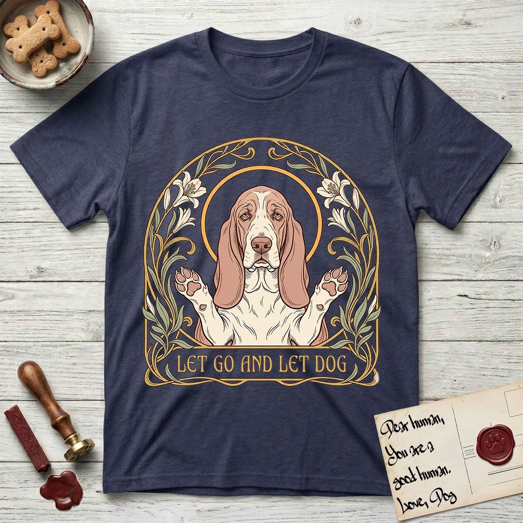 Let Go and Let Dog Basset Hound T-Shirt flat lay in Navy, featuring an Art Nouveau botanical illustration of a haloed Basset Hound with paws raised in blessing.