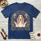 Let Go and Let Dog Basset Hound T-Shirt flat lay in Royal, featuring an Art Nouveau botanical illustration of a haloed Basset Hound with paws raised in blessing.
