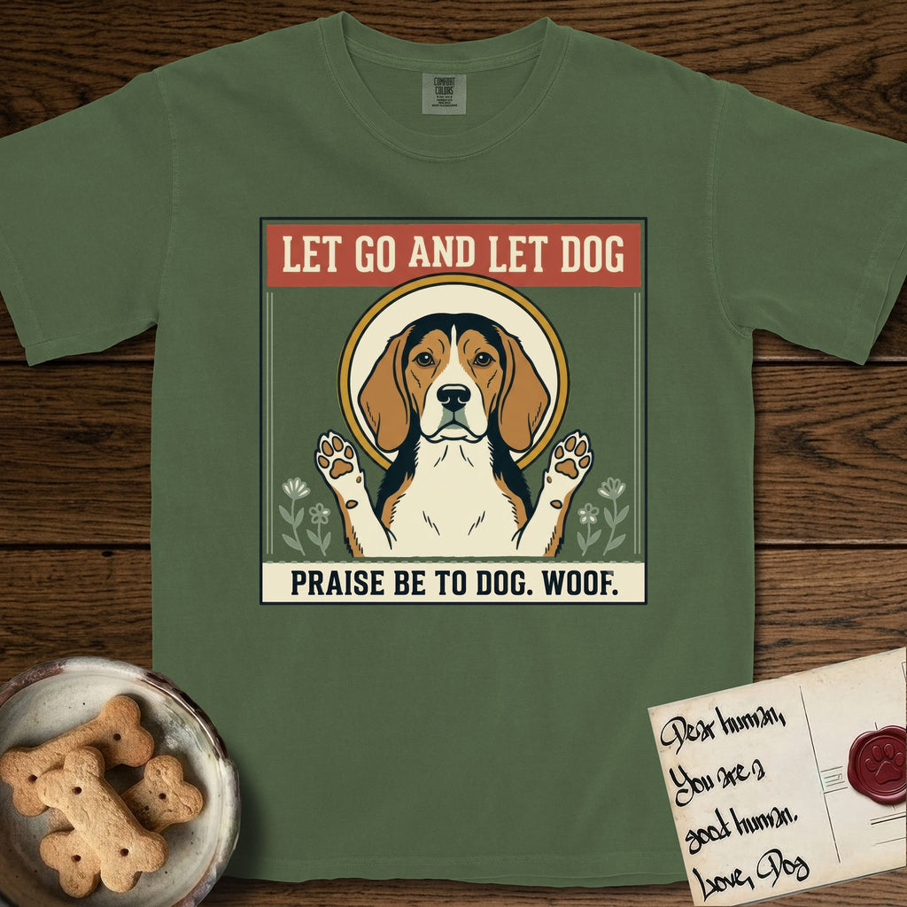 Let Go and Let Dog Beagle T-Shirt flat lay in Moss, featuring a vintage seed packet label with a haloed tricolor Beagle, paws raised, flanked by simple flower sprigs.