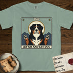 Let Go and Let Dog Bernese Mountain Dog T-Shirt flat lay in Bay, featuring a vintage tarot card with a haloed tricolor Bernese Mountain Dog, paws raised, mountains rising behind her shoulders.