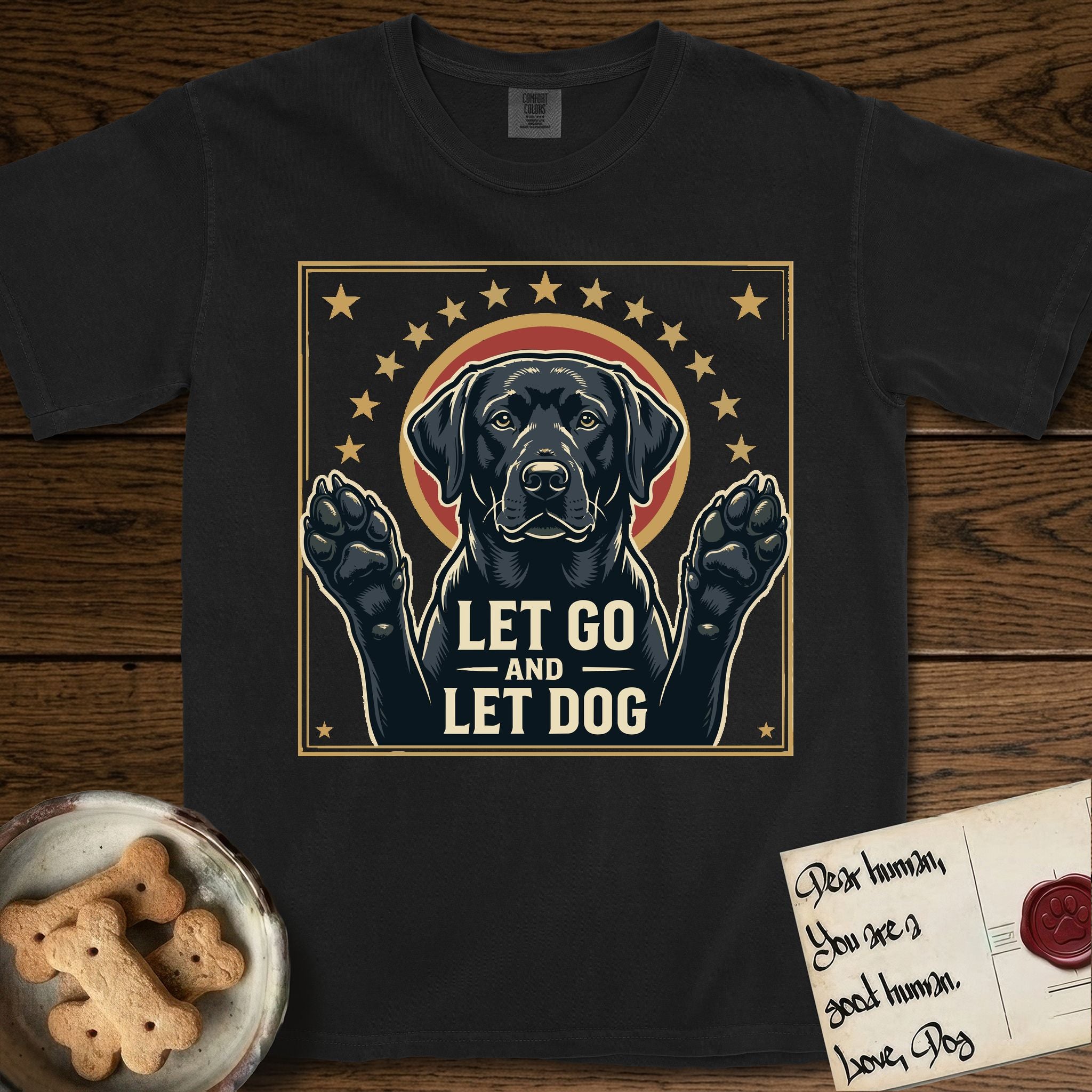Let Go and Let Dog Black Lab T-Shirt flat lay in Black, featuring a bold Americana star-badge of a haloed Black Lab with both front paws raised.