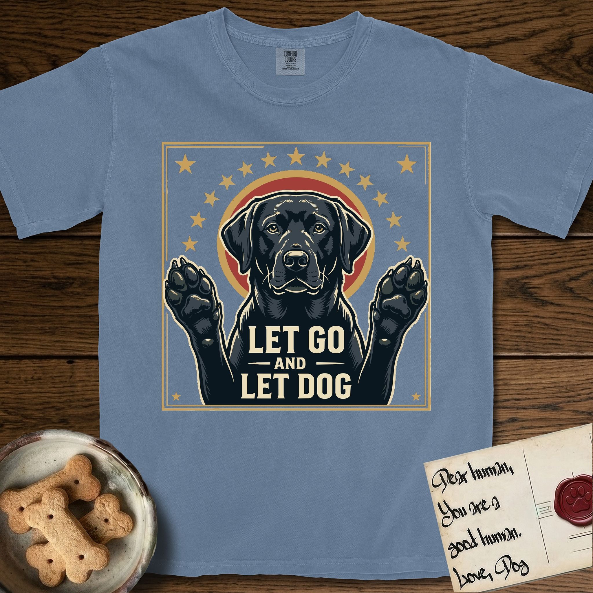 Let Go and Let Dog Black Lab T-Shirt flat lay in Blue Jean, featuring a bold Americana star-badge of a haloed Black Lab with both front paws raised.