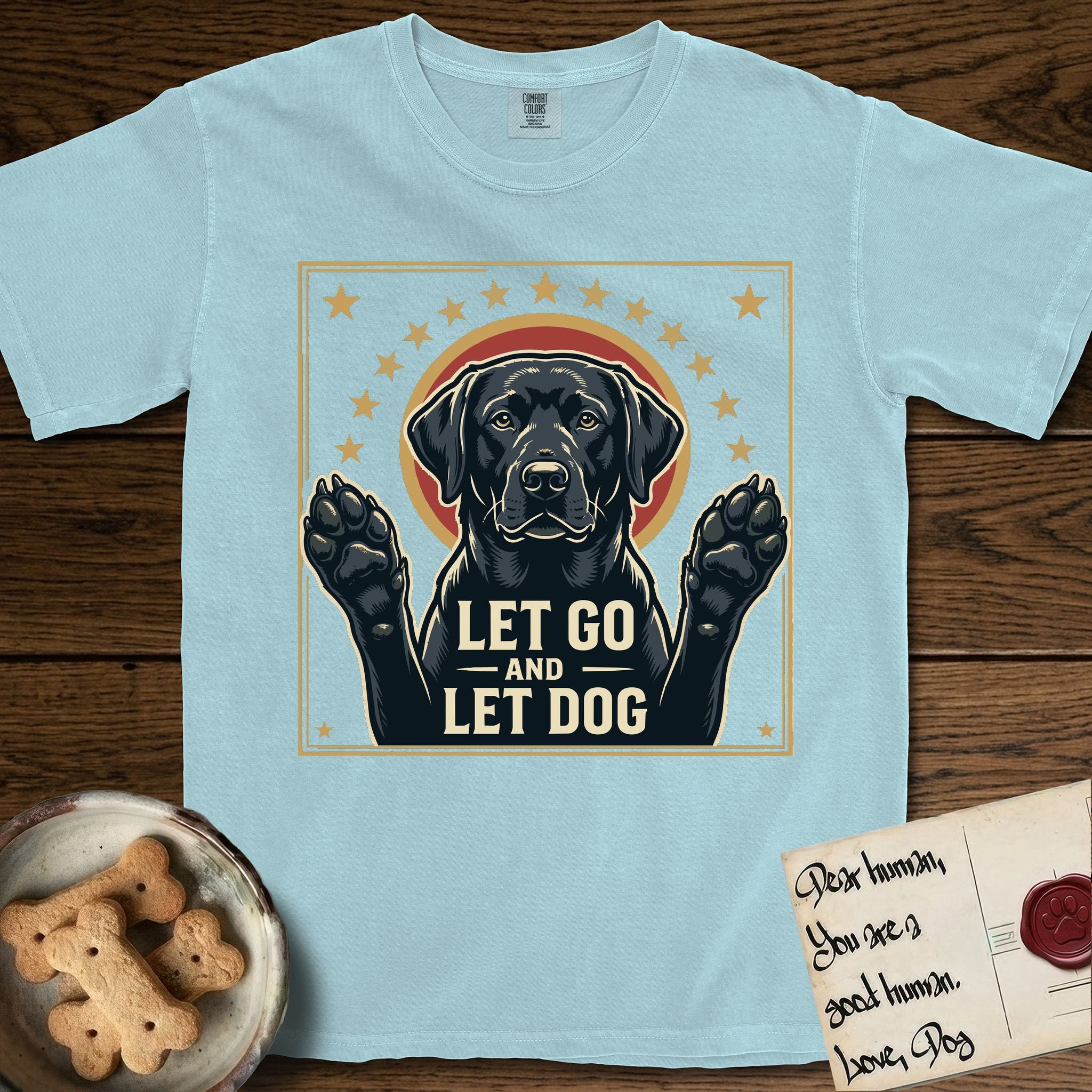 Let Go and Let Dog Black Lab T-Shirt flat lay in Chambray, featuring a bold Americana star-badge of a haloed Black Lab with both front paws raised.