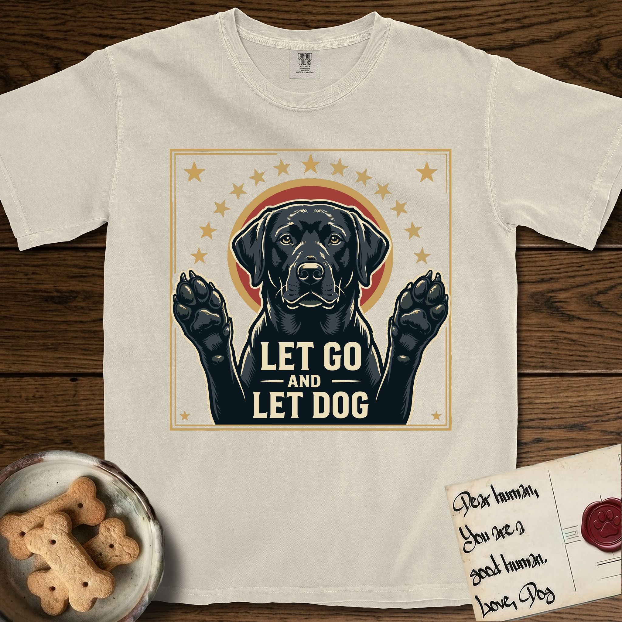 Let Go and Let Dog Black Lab T-Shirt flat lay in Ivory, featuring a bold Americana star-badge of a haloed Black Lab with both front paws raised.