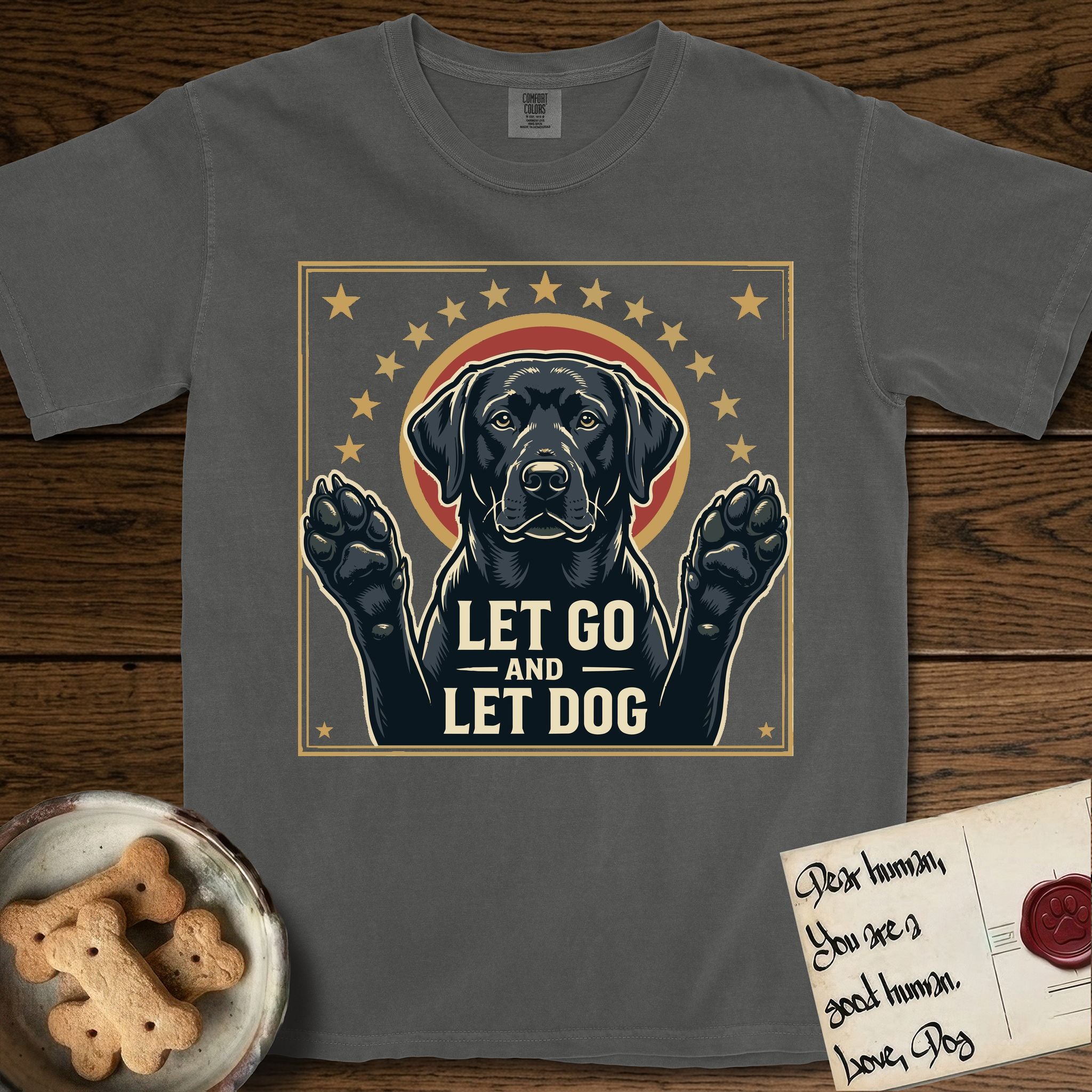 Let Go and Let Dog Black Lab T-Shirt flat lay in Pepper, featuring a bold Americana star-badge of a haloed Black Lab with both front paws raised.