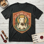 Let Go and Let Dog Bull Terrier T-Shirt flat lay in Black, featuring a vintage badge of a haloed Bull Terrier with paws raised in blessing.