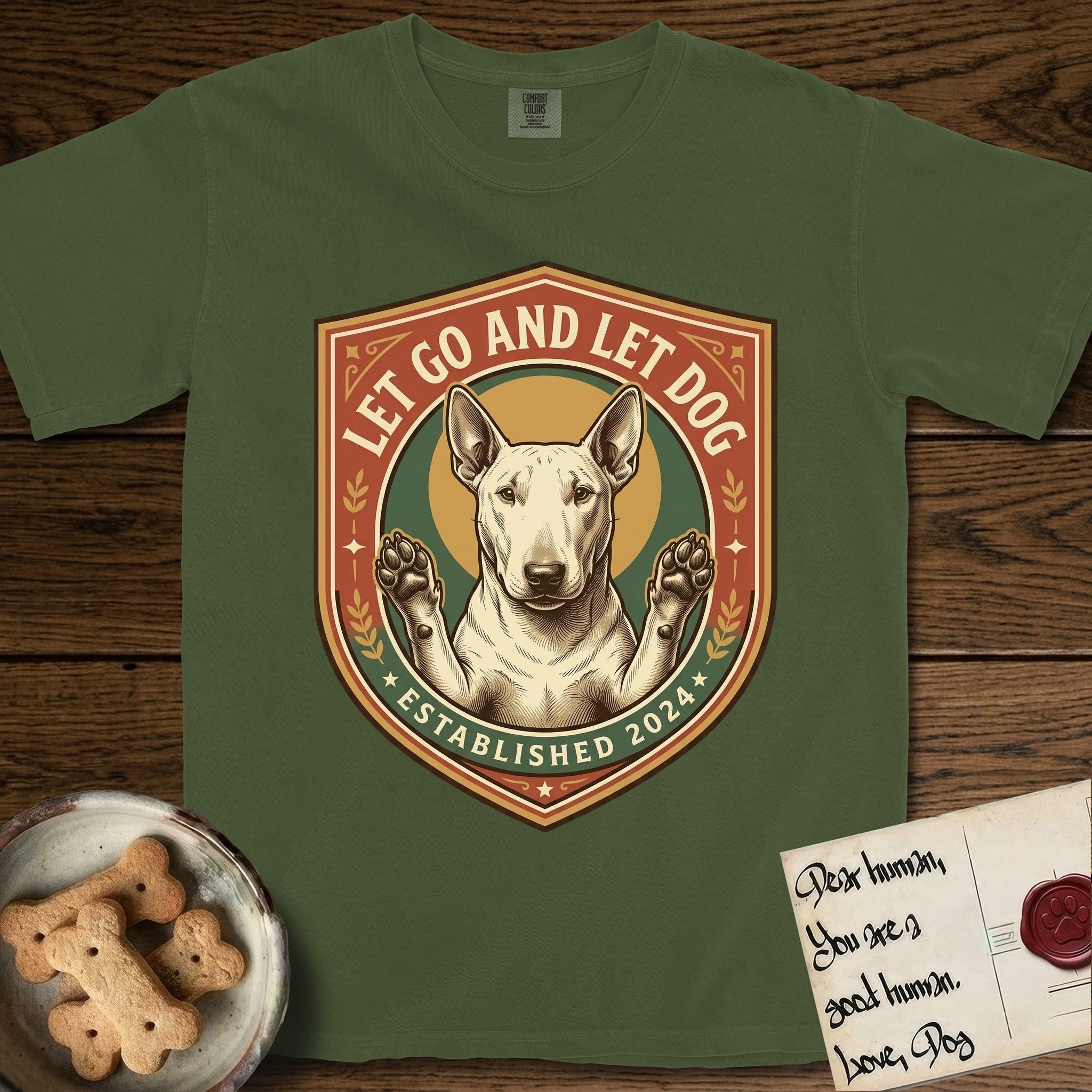 Let Go and Let Dog Bull Terrier T-Shirt flat lay in Hemp, featuring a vintage badge of a haloed Bull Terrier with paws raised in blessing.