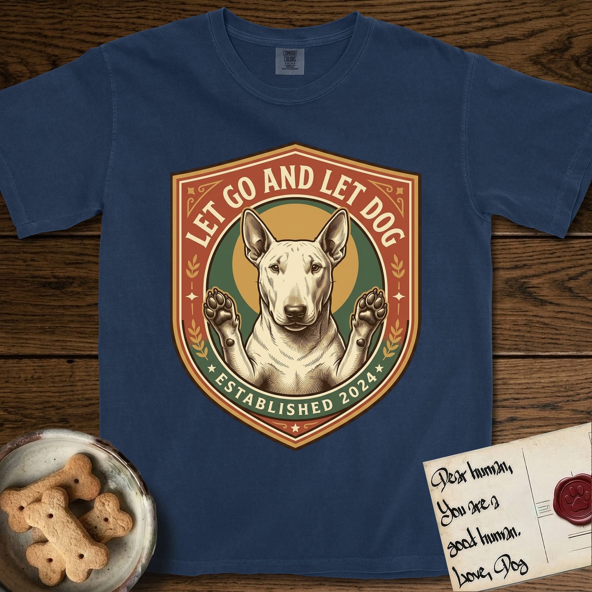 Let Go and Let Dog Bull Terrier T-Shirt flat lay in True Navy, featuring a vintage badge of a haloed Bull Terrier with paws raised in blessing.