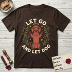 Let Go and Let Dog Dachshund T-Shirt flat lay in Dark Chocolate, featuring a folk-art botanical illustration of a haloed Dachshund sitting up with front paws raised.