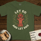 Let Go and Let Dog Dachshund T-Shirt flat lay in Hemp, featuring a folk-art botanical illustration of a haloed Dachshund sitting up with front paws raised.