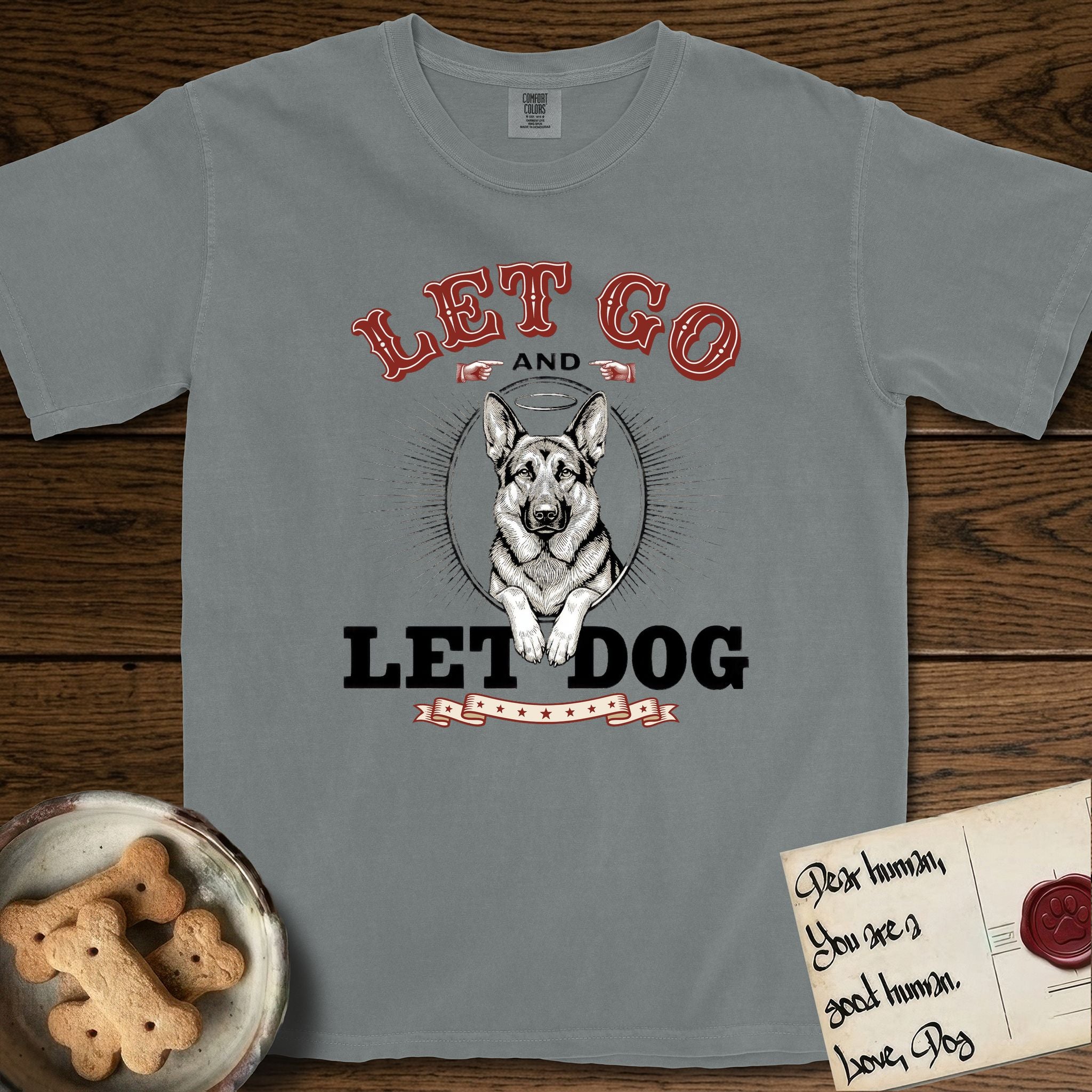 Let Go and Let Dog German Shepherd T-Shirt flat lay in Granite, featuring a vintage letterpress engraving of a haloed German Shepherd framed by a sunburst oval.