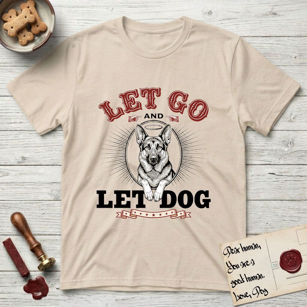 Let Go and Let Dog German Shepherd T-Shirt flat lay in Sand, featuring a vintage letterpress engraving of a haloed German Shepherd framed by a sunburst oval.