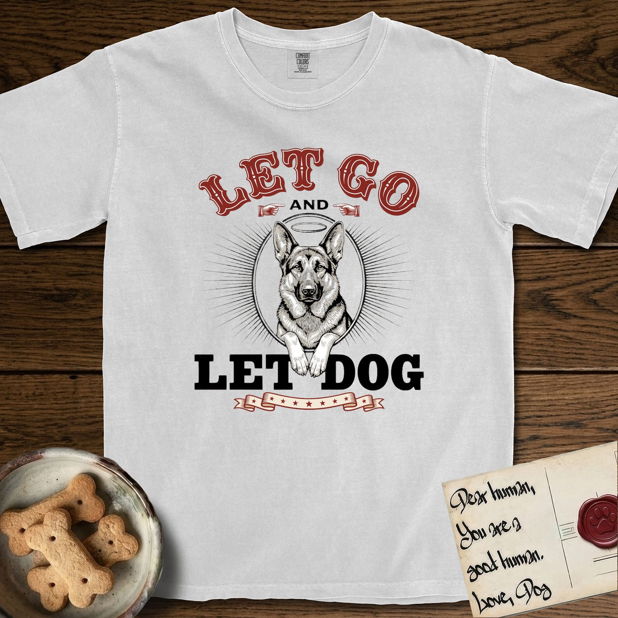 Let Go and Let Dog German Shepherd T-Shirt flat lay in White, featuring a vintage letterpress engraving of a haloed German Shepherd framed by a sunburst oval.