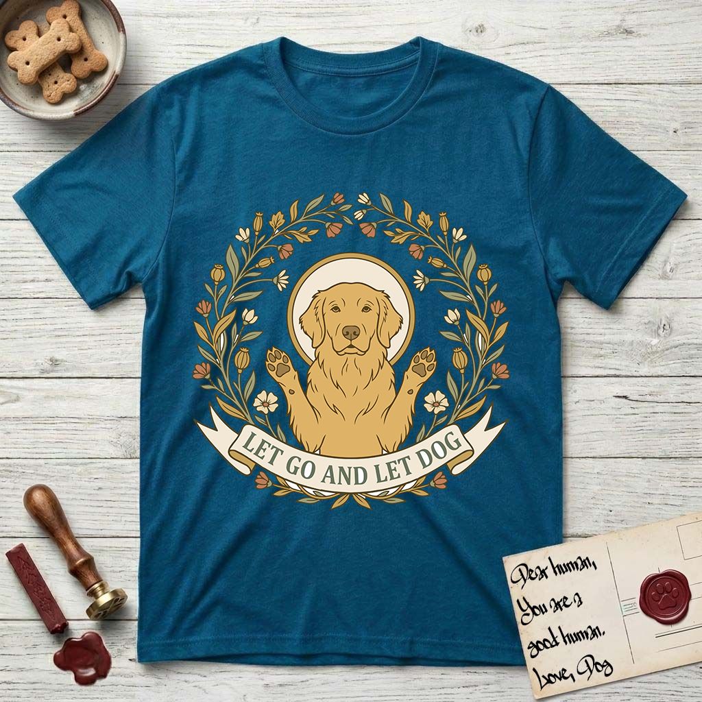 Let Go and Let Dog Golden Retriever T-Shirt flat lay in Antique Sapphire, featuring an Art Nouveau wildflower wreath around a haloed Golden Retriever with front paws raised.