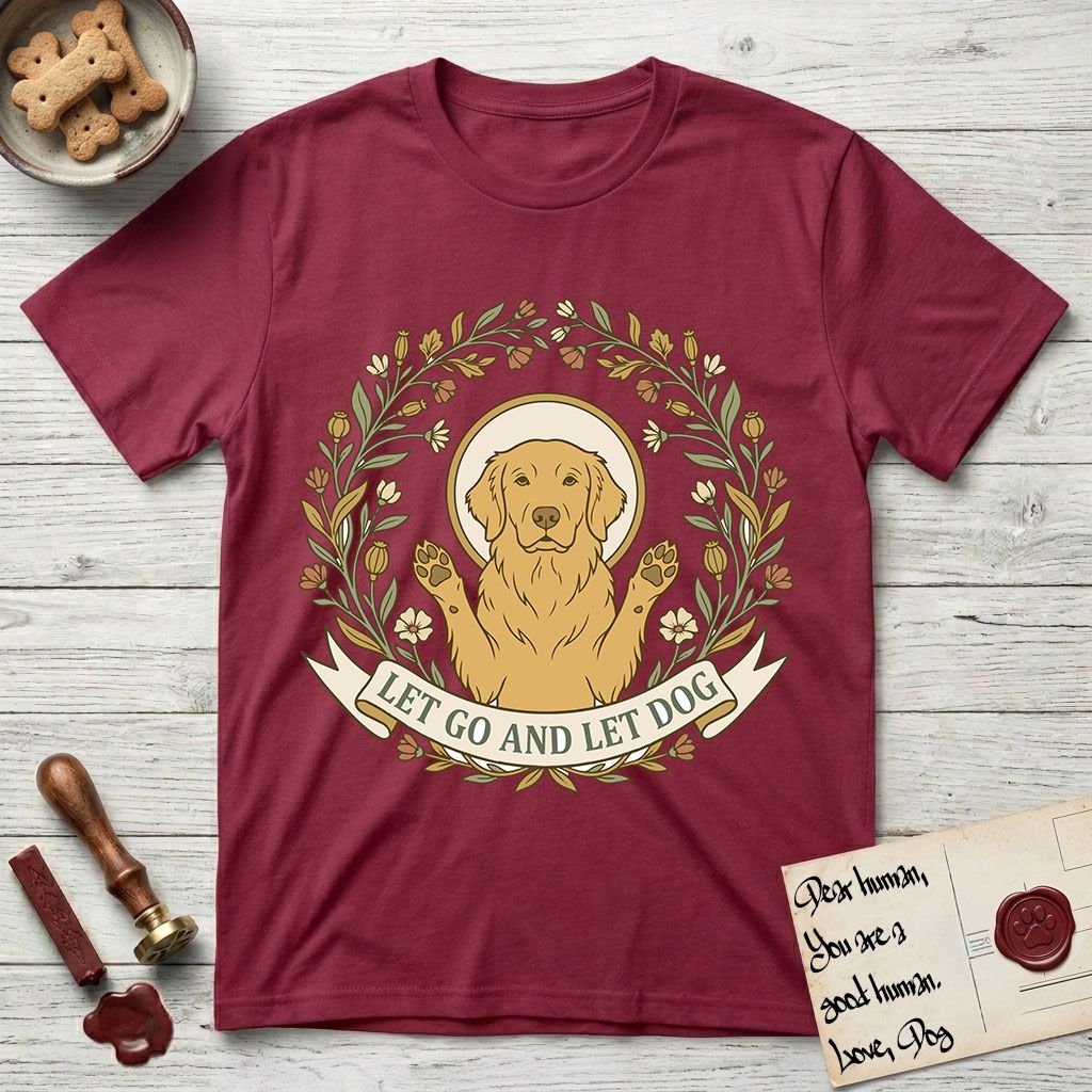 Let Go and Let Dog Golden Retriever T-Shirt flat lay in Cardinal Red, featuring an Art Nouveau wildflower wreath around a haloed Golden Retriever with front paws raised.