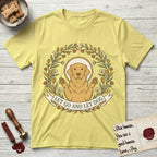 Let Go and Let Dog Golden Retriever T-Shirt flat lay in Cornsilk, featuring an Art Nouveau wildflower wreath around a haloed Golden Retriever with front paws raised.
