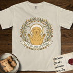 Let Go and Let Dog Golden Retriever T-Shirt flat lay in Ivory, featuring an Art Nouveau wildflower wreath around a haloed Golden Retriever with front paws raised.