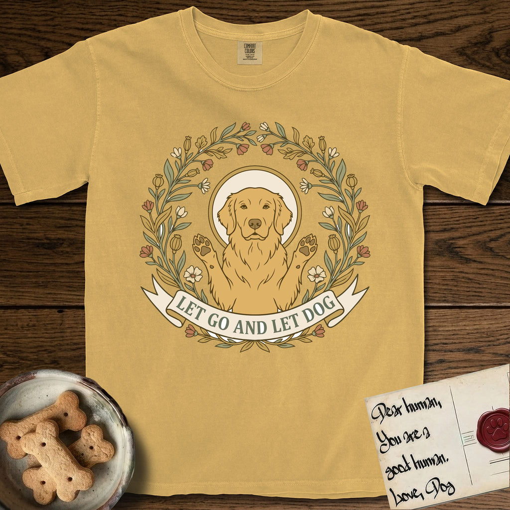 Let Go and Let Dog Golden Retriever T-Shirt flat lay in Mustard, featuring an Art Nouveau wildflower wreath around a haloed Golden Retriever with front paws raised.