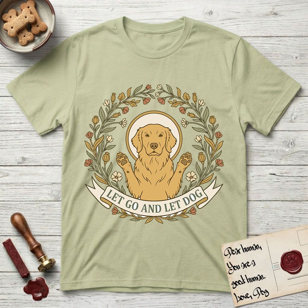 Let Go and Let Dog Golden Retriever T-Shirt flat lay in Pistachio, featuring an Art Nouveau wildflower wreath around a haloed Golden Retriever with front paws raised.