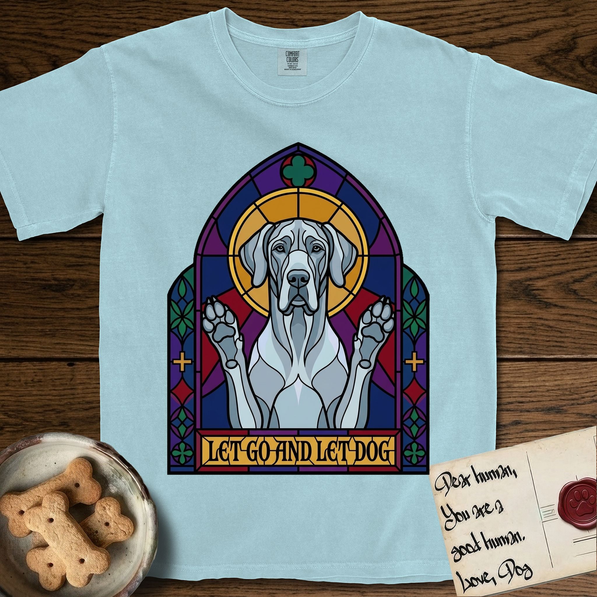 Let Go and Let Dog Great Dane T-Shirt flat lay in Chambray, featuring a stained-glass cathedral window of a haloed Great Dane with paws raised.