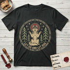 Let Go and Let Dog Husky T-Shirt flat lay in Black, featuring a winter woodland seal of a haloed Husky sitting with paws raised among pine trees.