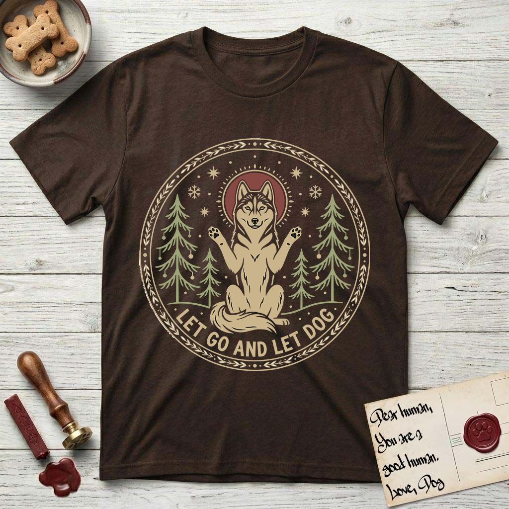 Let Go and Let Dog Husky T-Shirt flat lay in Dark Chocolate, featuring a winter woodland seal of a haloed Husky sitting with paws raised among pine trees.