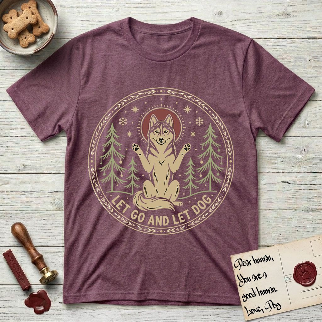 Let Go and Let Dog Husky T-Shirt flat lay in Heather Maroon, featuring a winter woodland seal of a haloed Husky sitting with paws raised among pine trees.