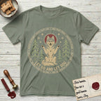 Let Go and Let Dog Husky T-Shirt flat lay in Sage, featuring a winter woodland seal of a haloed Husky sitting with paws raised among pine trees.