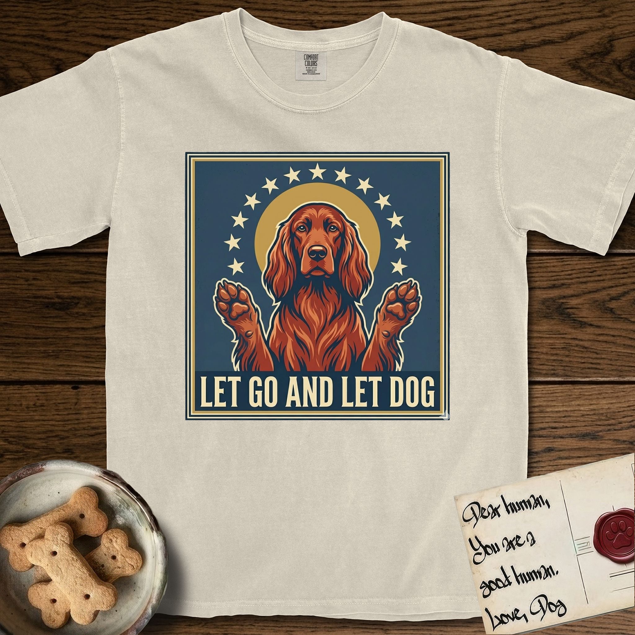 Let Go and Let Dog Irish Setter T-Shirt flat lay in Ivory, featuring a vintage devotional poster of a haloed Irish Setter with paws raised and a ring of stars.
