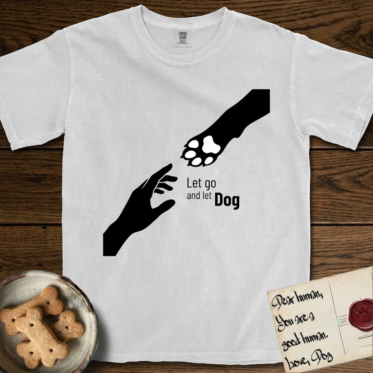 Let Go and Let Dog Paw T-Shirt flat lay in White, featuring a minimalist silhouette of a human hand and a Dog paw reaching toward each other, almost touching.