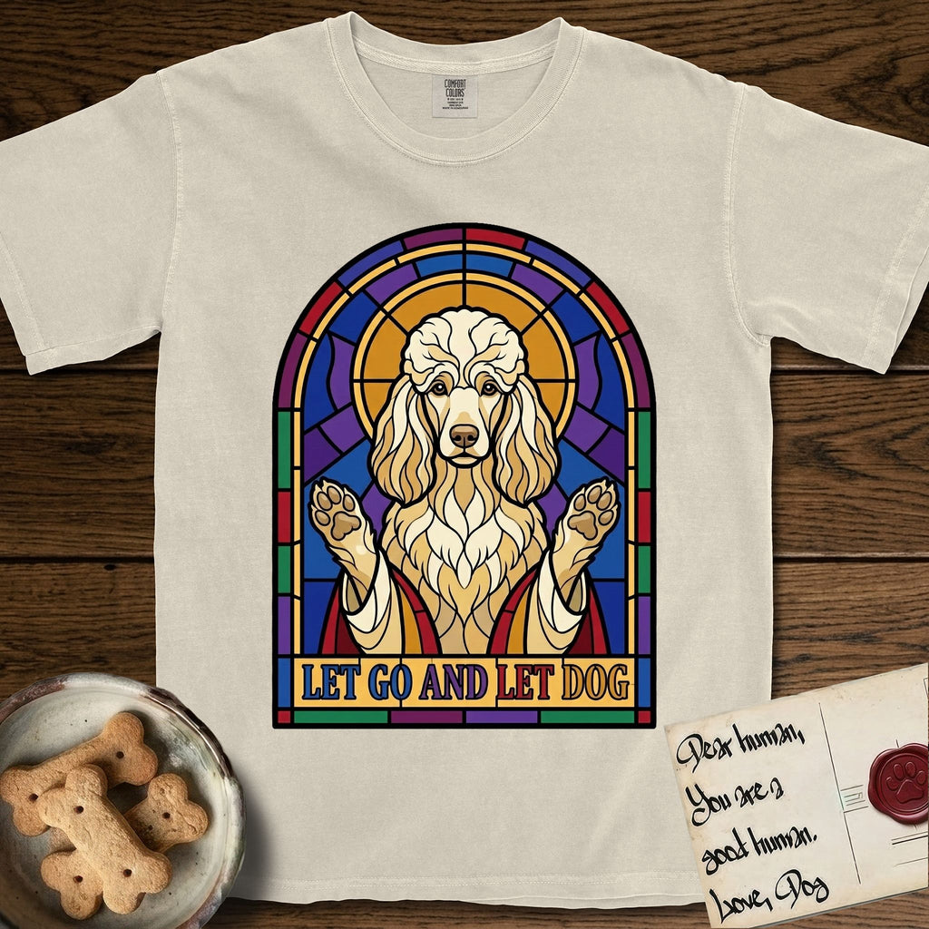 Let Go and Let Dog Poodle T-Shirt flat lay in Ivory, featuring a stained-glass illustration of a haloed Poodle with paws raised.