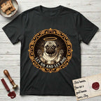 Let Go and Let Dog Pug T-Shirt flat lay in Black, featuring a baroque medallion engraving of a haloed Pug with paws raised, framed in gold scrollwork.