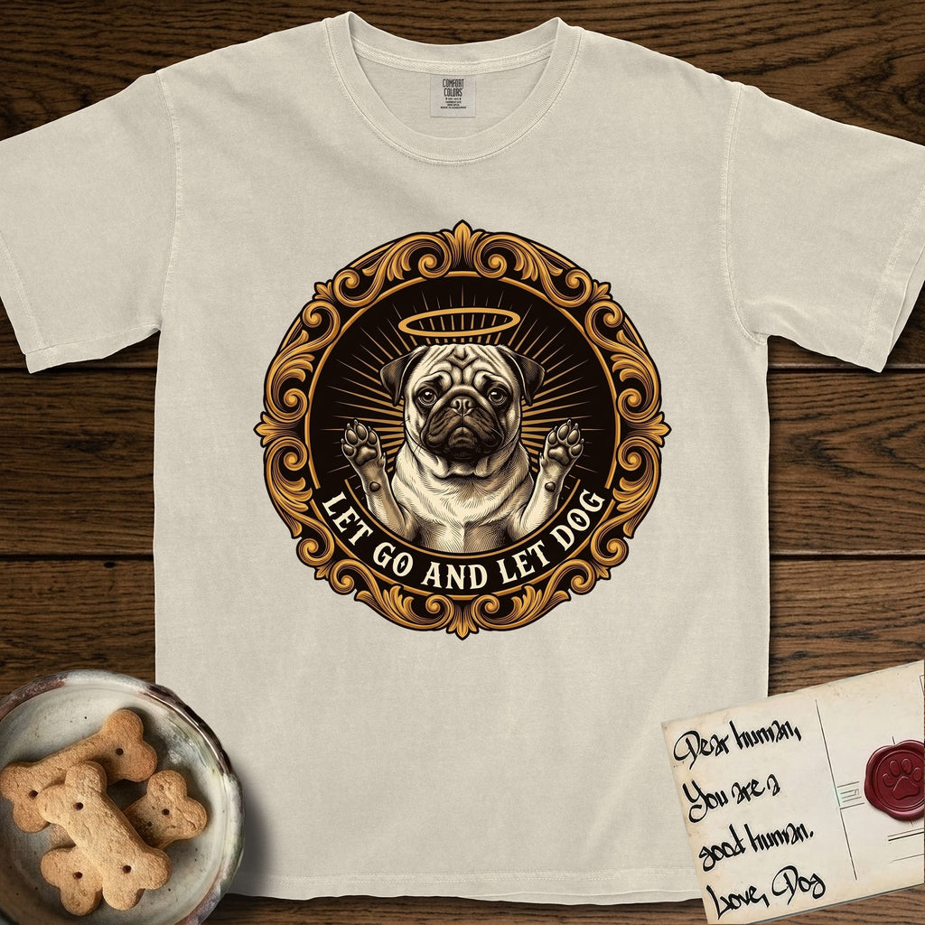 Let Go and Let Dog Pug T-Shirt flat lay in Ivory, featuring a baroque medallion engraving of a haloed Pug with paws raised, framed in gold scrollwork.