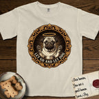 Let Go and Let Dog Pug T-Shirt flat lay in Ivory, featuring a baroque medallion engraving of a haloed Pug with paws raised, framed in gold scrollwork.